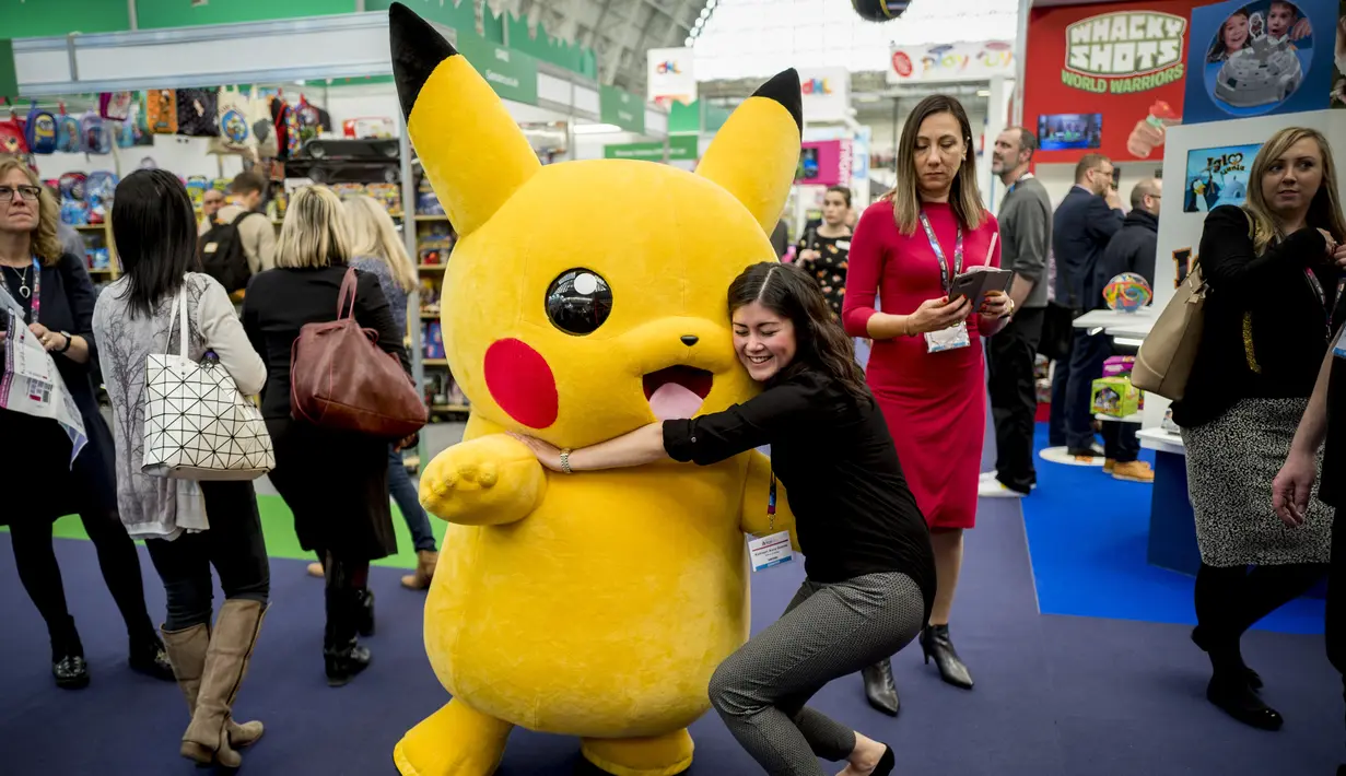 Seorang pengunjung berpose dengan karakter kartun Pikachu dari Pokemon saat Toy Fair atau Pameran Mainan tahunan di Olympia, London, Inggris, Selasa (23/1). Pameran ini menghadirkan lebih dari 250 perusahaan mainan. (AFP PHOTO/Tolga AKMEN)