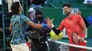 Petenis Italia, Lorenzo Musetti (kiri) berjabat tangan dengan petenis Serbia, Novak Djokovic pada babak 16 besar Monte Carlo Open 2023 di Monte Carlo, Jumat (14/04/2023) dini hari WIB. Musetti menang dengan skor 4-6, 7-5, 6-4. (AFP/Valery Hache)