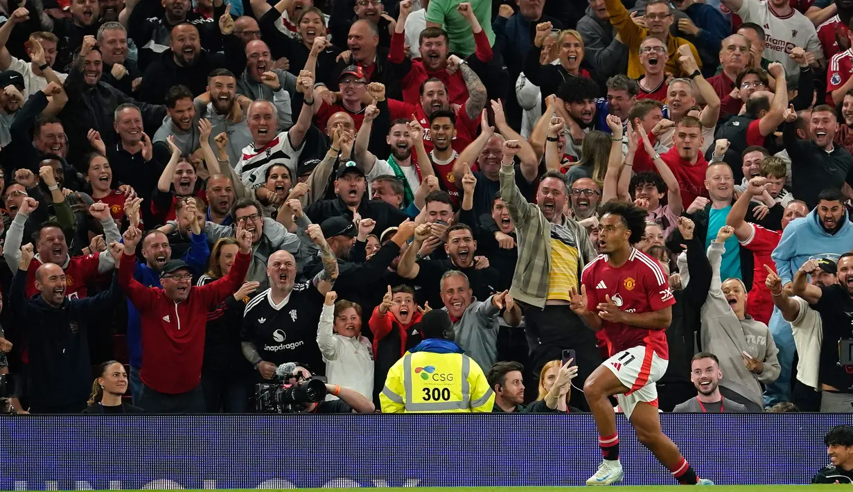 Pemain Manchester United, Joshua Zirkzee melakukan selebrasi usai mencetak gol pembuka saat pertandingan sepak bola Liga Premier Inggris melawan Fulham di stadion Old Trafford, Jumat 16 Agustus 2024. (AP Photo/Dave Thompson)