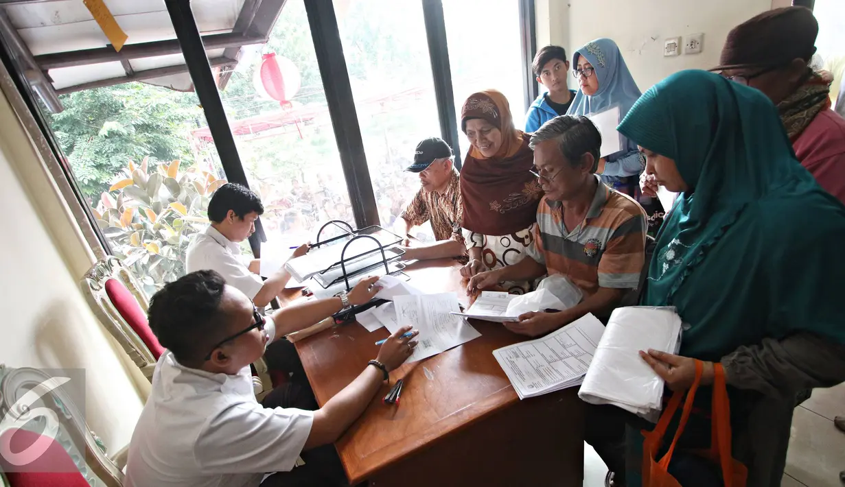 Petugas memberikan informasi kepada warga terkait pembuatan akte kelahiran dan e-KTP di Jakarta Timur, Senin (28/12). Proses pengurusan yang lebih mudah membuat warga membuat akte dan e-KTP jelang pergantian tahun. (Liputan6.com/Immnuel Antonius)