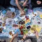 Orang-orang berbagi makanan dengan kerabat saat tiba waktu berbuka puasa di Taksim Square, Istanbul, Turki, Rabu (16/5). (Yasin AKGUL/AFP)