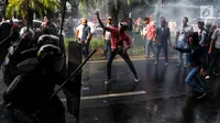 Perusuh melempari polisi saat simulasi pengamanan Pemilu 2019 di depan Gedung KPU, Jakarta, Jumat (15/3). Simulasi diikuti personel gabungan dari TNI dan Polri. (Liputan6.com/JohanTallo)