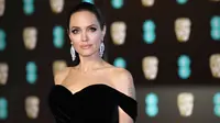 Aktris Angelina Jolie berpose saat tiba di BAFTA Awards 2018 di London, Inggris (18/2). Angelina tampil cantik dan seksi mengenakan gaun berwarna hitam dengan pundak terbuka. (Photo by Vianney Le Caer/Invision/AP)