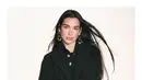 Dua Lipa memancarkan pesona high-fashion khas CHANEL dengan berbagai gaya yang berbeda namun tetap mempertahankan estetika elegan dan modern. Pada salah satu potret, Dua Lipa terlihat mengenakan setelan denim oversized dengan detail sulaman berkilauan yang memberikan efek glamor pada gaya kasualnya. [Dok/CHANEL].