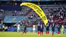 Paraglider Greenpeace mendarat di lapangan sebelum pertandingan Grup F Euro 2020  antara Prancis dan Jerman di Allianz Arena, Munich, Jerman, Selasa (15/6/2021). Sang aktivis kemungkinan mengalami patah tulang engkel ketika mendarat. (AP Photo/Matthias Schrader, Pool)