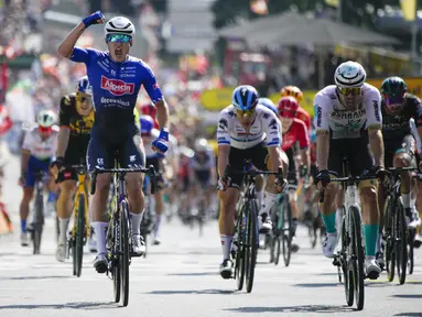 Jasper Philipsen melakukan selebrasi saat melewati garis finis di depan pebalap Jerman Phil Bauhaus yang menempati posisi kedua (kanan), untuk memenangkan etape ketiga balap sepeda Tour de France di Bayonne, Prancis, Senin (3/7/2023). (AP Photo/Daniel Cole)