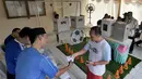 Warga menerima surat suara untuk mencoblos pada pelaksanaan Pilkada Serentak 2018 di TPS 31 Mutiara Sentul, Bogor, Rabu (27/6). TPS ini didekorasi dengan konsep piala dunia untuk menarik minat pemilih agar hadir dalam pencoblosan (Merdeka.com/Arie Basuki)