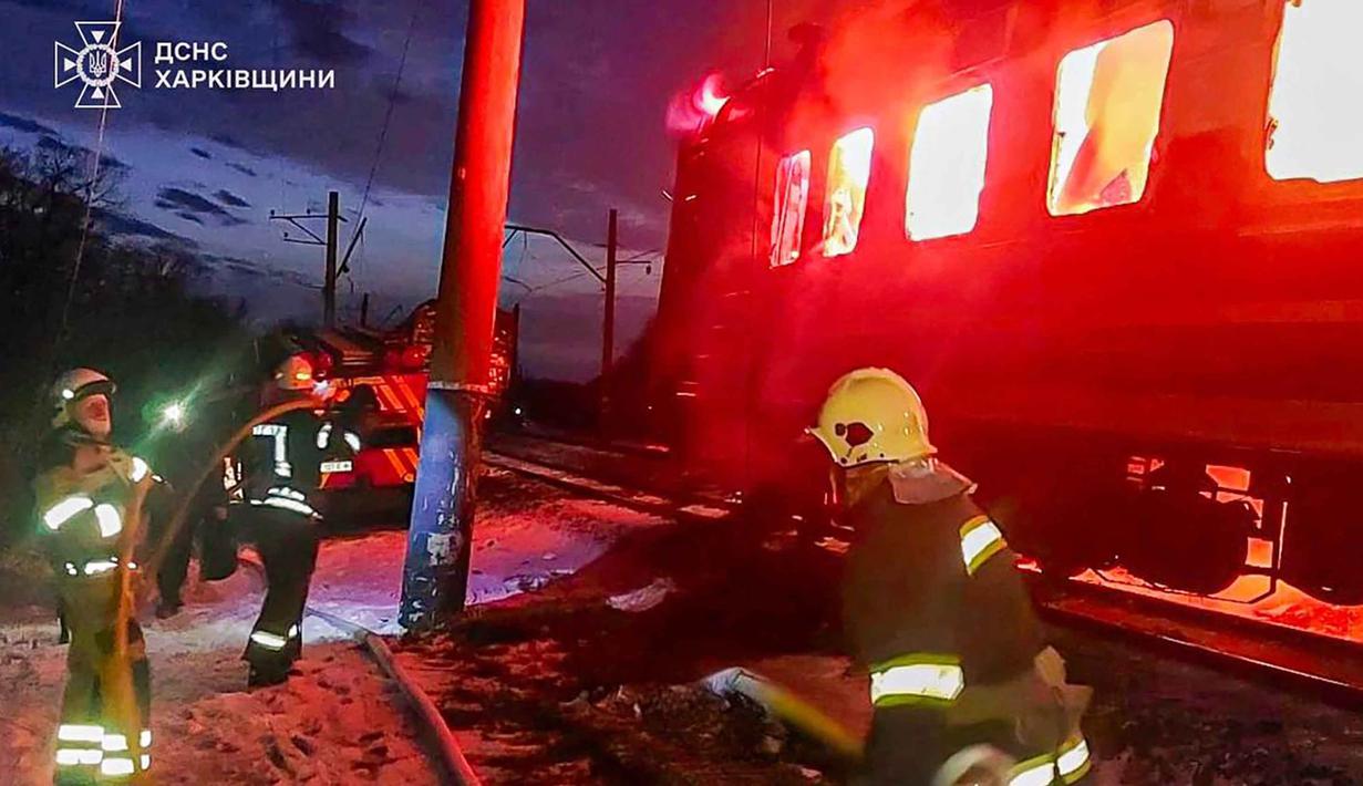 Dalam foto yang dirilis oleh Layanan Darurat Ukraina pada 27 Januari 2026 ini, para penyelamat Ukraina berupaya memadamkan api di gerbong kereta api setelah serangan udara di lokasi yang tidak diungkapkan di wilayah Kharkiv, di tengah invasi Rusia ke Ukraina. Serangan pesawat nirawak (drone) Rusia menghantam sebuah kereta penumpang sipil di wilayah Kharkiv, Ukraina. (Handout/UKRAINIAN EMERGENCY SERVICE/AFP)