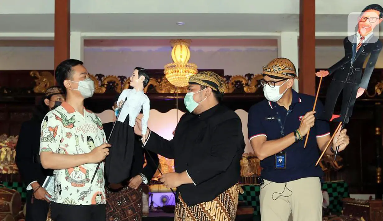 Menteri Parekraf Sandiaga Uno (kanan) dan Walikota Solo Gibran Raka Bumi (kiri) menerima wayang di Solo, Jawa Tengah, Sabtu (09/10/2021). Pada kunjungan ke Solo, Sandiaga sepakat untuk mengembangkan kesenian dan ekonomi kreatif untuk peningkatan ekonomi bagi masyarakat. (Liputan6.com/HO/Parekraf)