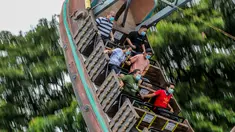 Pengunjung yang mengenakan masker menikmati wahana di taman hiburan Enchanted Kingdom di Provinsi Laguna, Filipina (18/10/2020). Taman hiburan tersebut kembali dibuka untuk pengunjung. (Xinhua/Rouelle Umali)