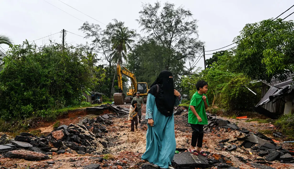 Sejumlah ruas jalan di Tumpat, negara bagian Kelantan, Malaysia, pada Rabu 4 Desember 2024 rusak tergerus banjir. (MOHD RASFAN/AFP)