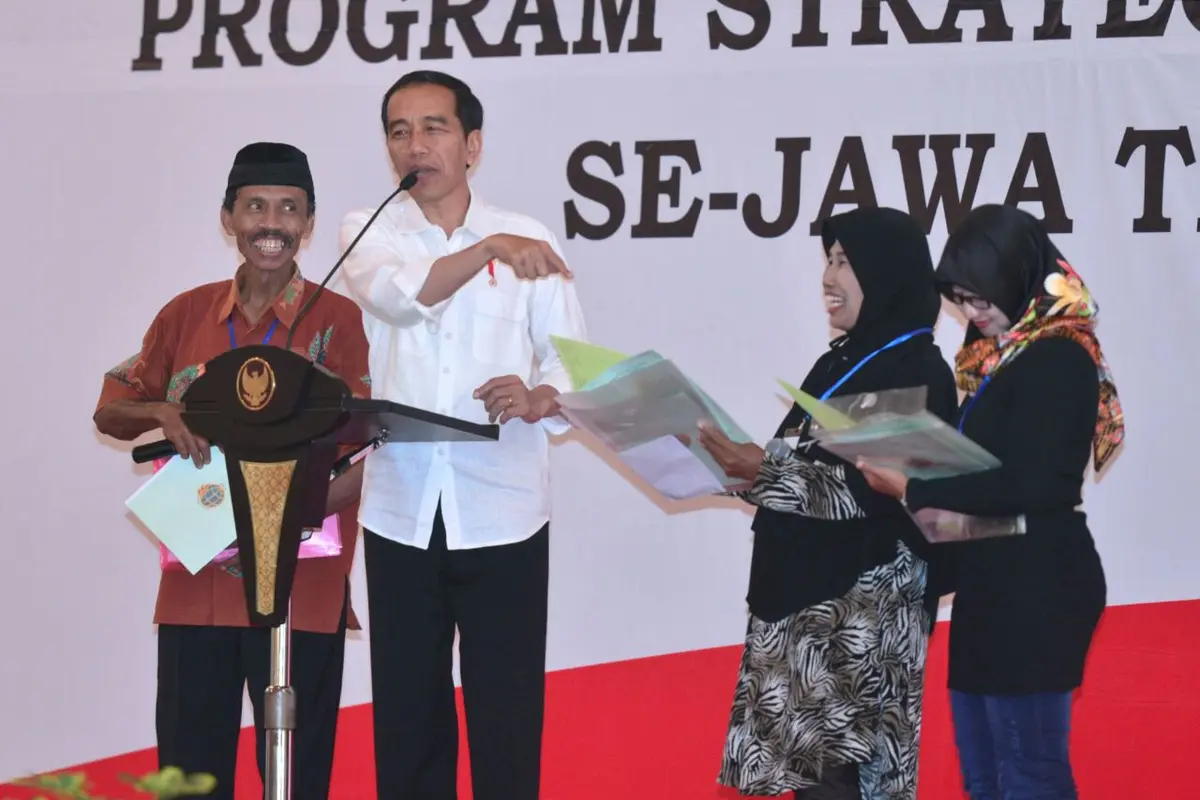 Jokowi menyerahkan sertifikat hak atas tanah program strategis nasional di Gedung New Sari Utama Convention Hall, Jember.