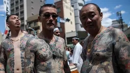 Peserta dengan tato tradisional di tubuhnya mengikuti Festival Sanja Matsuri di luar kuil Sensoji, distrik Asakusa, Tokyo, Minggu (20/5). Dan hanya di Festival ini para Yakuza menampakkan diri dan berbaur dengan masyarakat lainnya. (AFP/Behrouz MEHRI)