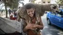 Seorang anak tersenyum setelah membeli seekor domba untuk perayaan Idul Adha di sebuah pasar di pinggiran Rabat, Maroko, Kamis (30/7/2020). (AP Photo/Mosaab Elshamy)