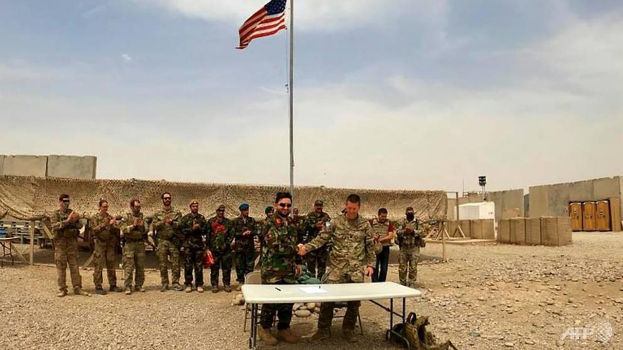 Seorang tentara AS dan Afghanistan berjabat tangan selama upacara penyerahan di Kamp Antonik di provinsi Helmand. (Foto: AFP)