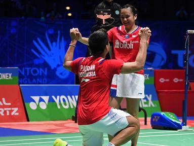 Pasangan Indonesia, Praveen Jordan/Melati Daeva Oktavianti melakukan selebrasi usai meraih juara All England dengan mengalahkan wakil Thailand Dechapol Puavaranukroh/Sapsiree Taerattanachai di Birmingham Arena, Minggu (15/3/2020). (AFP/Oli Scarff)