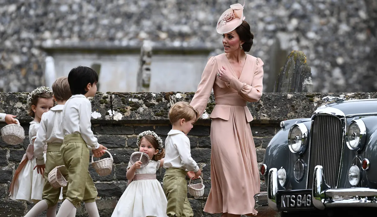 Kate Middleton bersama anak-anak pengiring pengantin menuju lokasi pernikahan sang adik, Pippa Middleton dan James Mathews di Gereja St. Mark, barat London, Sabtu (20/5). Kate Middleton memilih tampil dengan gaun blush pink. (Justin TALLIS/Pool/AFP)