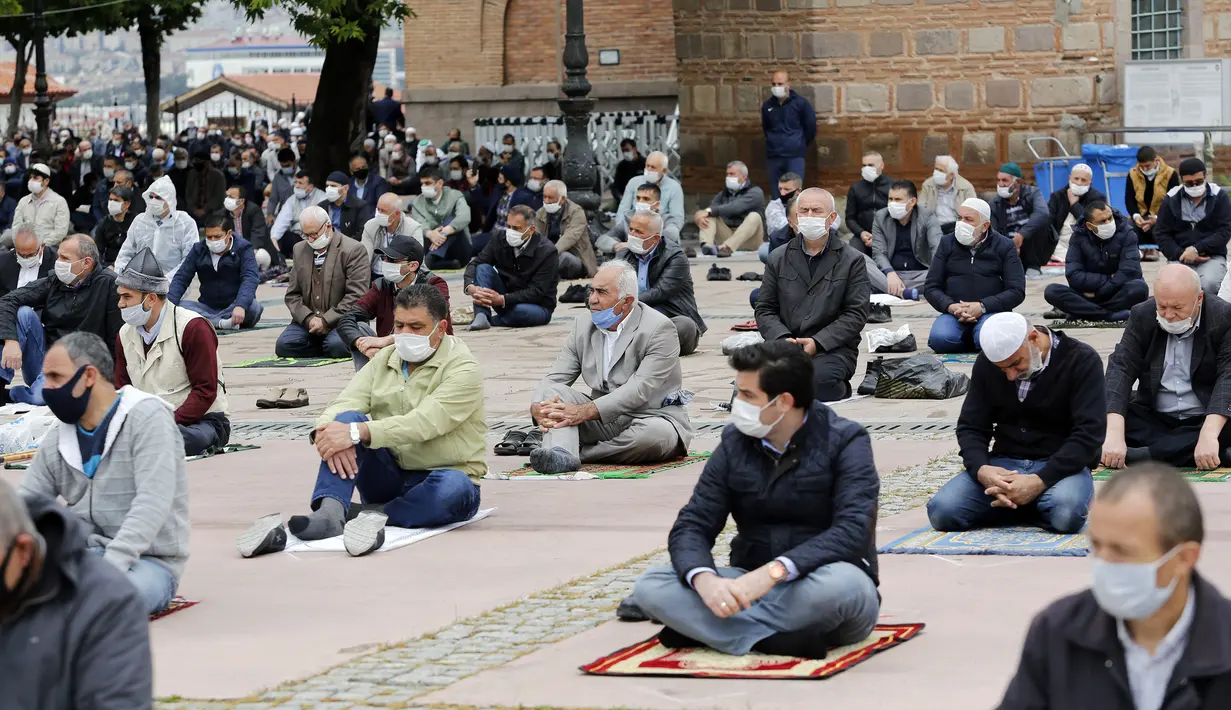 Warga yang mengenakan masker mengikuti salat Jumat dengan menjaga jarak di depan sebuah masjid di Ankara, 29 Mei 2020. Masjid-masjid di seluruh Turki pada Jumat (29/5) kembali dibuka, sebagai bagian proses normalisasi di tengah melambatnya penyebaran COVID-19 di negara itu. (Xinhua/Mustafa Kaya)