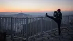 Seorang pejalan kaki mengabadikan kota Seoul dan menara Namsan dengan ponselnya selama matahari terbit di Korea Selatan (31/10). Seoul adalah ibu kota Korea Selatan yang berusia lebih dari 600 tahun. (AFP Photo/Ed Jones)