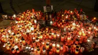 Ratusan lilin dinyalakan di depan foto jurnalis investigasi Slovakia Jan Kuciak di Wenceslas Square di Praha (26/2). Sebelumnya Jan Kuciak dan kekasihnya ditemukan tewas ditembak di rumah yang mereka tempati. (AFP Photo/Michal Cizek)