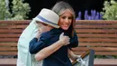 Ibu Negara AS, Melania Trump memeluk seorang anak pada saat menghadiri pembukaan Taman Bunny Mellon Healing di Rumah Sakit Nasional Anak di Washington, AS (29/4). (AP Photo/Pablo Martinez Monsivais)