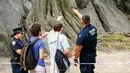 Saksi mata memberi kesaksian kepada petugas kepolisian setelah ledakan di Central Park, New York, Minggu (3/7). Seorang pemuda menjadi korban ledakan tersebut yang menyebabkan kakinya hampir putus. (Kena Betancur/AFP)
