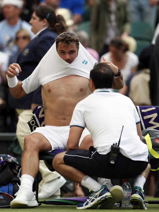 Stan Wawrinka mendapat perawatan dari tim medis setelah mengalami cedera ringan pada lutut kiri saat melawan etenis Rusia, Daniil Medvedev di  Wimbledon Tennis Championships 2017, London, (3/7/2017). Stan kalah 4-6, 6-3, 4-6, 1-6. (AP/Kirsty Wigglesworth)