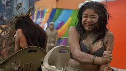 Wisatawan bermain di kolam lumpur selama Boryeong Mud Festival atau Festival Lumpur Boryeong di pantai Daecheon, Korea Selatan, Sabtu (20/7/2019). Festival ini dikenal sebagai festival paling populer di Korea Selatan dan berhasil mengundang ribuan turis dari seluruh penjuru dunia. (Minji SUH/AFP)