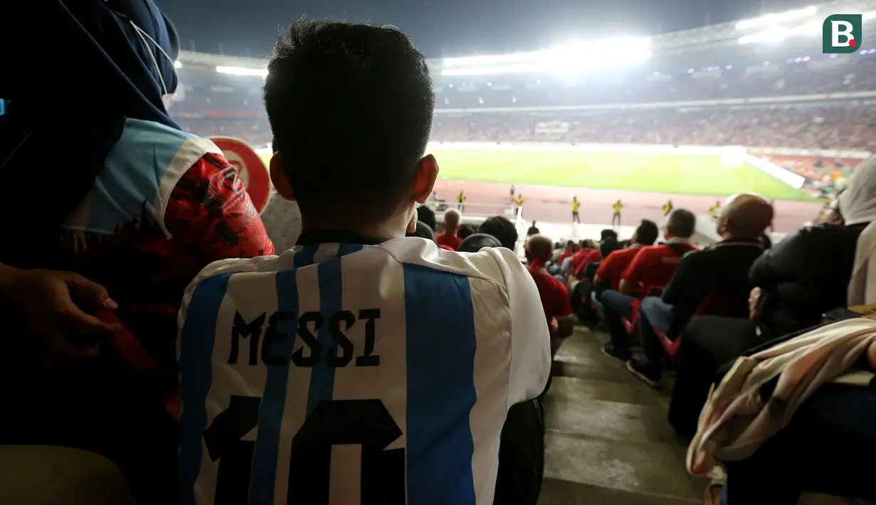 Suporter yang memakai jersey Lionel Messi menyaksikan laga Timnas Indonesia vs Argentina pada FIFA Matchday 2023 di Stadion Utama Gelora Bung Karno, Jakarta, Senin (19/6/2023). (Bola.com/Muhammad Iqbal Ichsan)