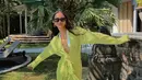 Di siang hari, Alyssa juga tidak ingin ketinggalan tropical vibes di Bali. Ia pun mengenakna bikini putih yang dipadukan dengan twisted shirt dress berwarna hijau neon (instagram/alyssadaguise)