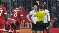 Wasit memberikan kartu merah kepada bek Besiktas, Domagoj Vida, saat melawan Bayern Munchen pada laga Liga Champions di Stadion Allianz Arena, Munchen, Selasa (20/2/2018). Munchen menang 5-0 atas Besiktas. (AFP/Thomas Kienzle)