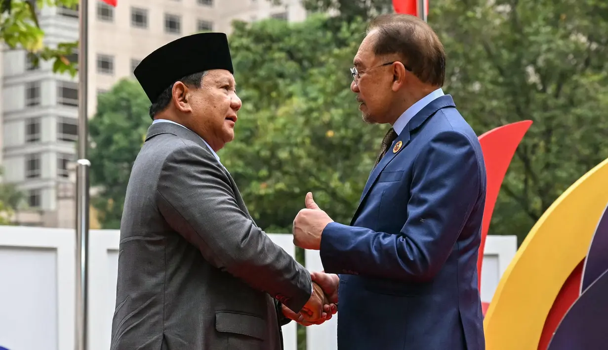 Presiden Republik Indonesia Prabowo Subianto (kiri) bersalaman dengan Perdana Menteri Malaysia Anwar Ibrahim sebelum sesi pleno di Konferensi Tingkat Tinggi (KTT) ke-46 ASEAN di Kuala Lumpur pada 26 Mei 2025. (MOHD RASFAN/POOL/AFP)