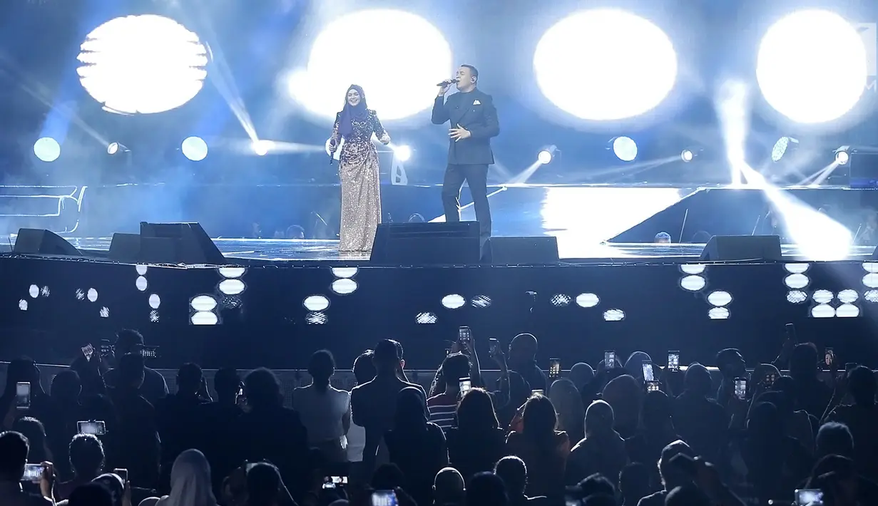 Penyanyi Siti Nurhaliza (kiri) berduet dengan Tulus dalam konser 'Dato Sri Siti Nurhaliza on Tour' di Istora Senayan, Jakarta, Kamis (21/2). Tulus muncul saat Siti Nurhaliza tengah membawakan lagu Seindah Biasa. (Fimela.com/Bambang E Ros)