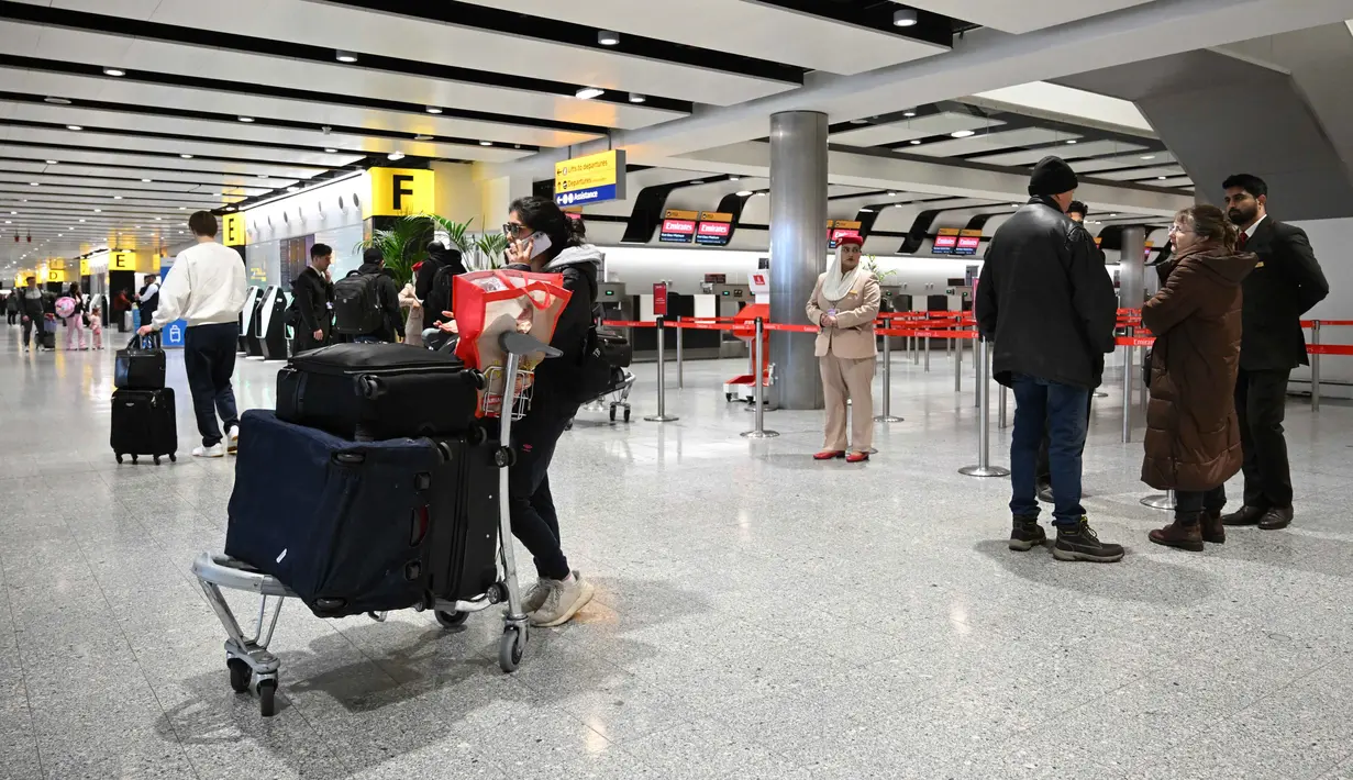 Langkah ini sebagai tindakan pencegahan, untuk memastikan keselamatan penerbangan dan awak pesawat, penumpang, serta melindungi wilayah UEA. Tampak dalam foto, para penumpang berkumpul di area check-in Emirates yang ditutup di Bandara London Heathrow di London barat pada Minggu 1 Maret 2026, karena penerbangan sangat terganggu menyusul serangan Amerika Serikat dan Israel terhadap Iran. (JUSTIN TALLIS/AFP)