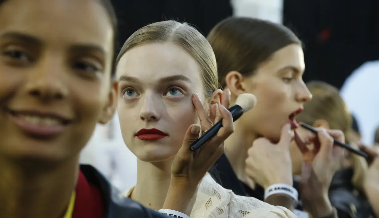 Model saat dirias di belakang panggung sebelum memamerkan koleksi busana wanita Fall Winter 2020 Jil Sander selama Fashion Week di Milan, Italia, Rabu, (19/2/2020). (AP Photo/Domenico Stinellis)