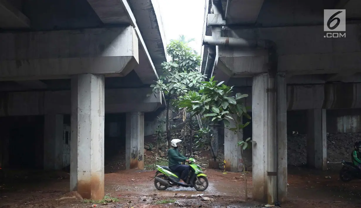 Pengendara motor melintasi jalan setapak di kolong tol di kawasan Lebak Bulus, Jakarta, Selasa (13/2). Untuk menghindari macet sebagian pengendara memanfaatkan jalan setapak tersebut untuk memersingkat waktu tempuh. (Liputan6.com/Immanuel Antonius)