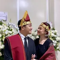 Dalam acara mangadati, Rianti tampil anggun dalam balutan kebaya hitam dan kain ulos merah. [@riantic/@__rose_makeupartist/@meli_makeuphairdowedding]