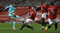 Gelandang Liverpool, Georginio (kiri) Wijnaldum menendang bola yang dihalangi oleh bek Manchester United, Luke Shaw dalam laga putaran keempat Piala FA di Stadion Old Trafford, Senin dinihari WIB (25/1/2021). Manchester United atau MU singkirkan Liverpool usai menang 3-2. (Phil Noble/Pool via AP)