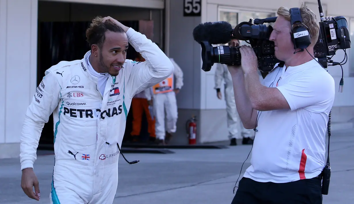 Pembalap Mercedes, Lewis Hamilton usai meraih kemenangan Formula Satu (F1) Grand Pix Jepang di Sirkuit Suzuka, Jepang (7/10). Pembalap Red Bull Racing Max Verstappen meraih posisi ketiga. (AP Photo/Toru Takahashi)