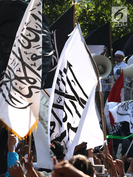 Massa Aksi Bela Tauhid mengibarkan bendera bertuliskan kalimat tauhid di depan Gedung Kemenko Polhukam, Jakarta, Jumat (26/10). Aksi diikuti ribuan orang dari berbagai organisasi Islam. (Merdeka.com/Imam Buhori)