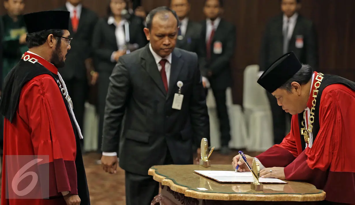 Ketua MK, Arief Hidayat (kanan) menandatangani berita acara Wakil Ketua MK Anwar Usman usai pengambilan sumpah, Jakarta, Senin (11/4/2016). Anwar dipilih berdasarkan musyawarah mufakat yang dilakukan secara tertutup. (Liputan6.com/Faizal Fanani)