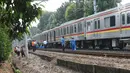 Sejumlah petugas KAI memeriksa keadaan kereta yang anjlok di dekat Stasiun Palmerah, Jakarta, Sabtu (13/10). Petugas masih menyelidiki penyebab anjloknya kereta tersebut. (Liputan6.com/Herman Zakharia)