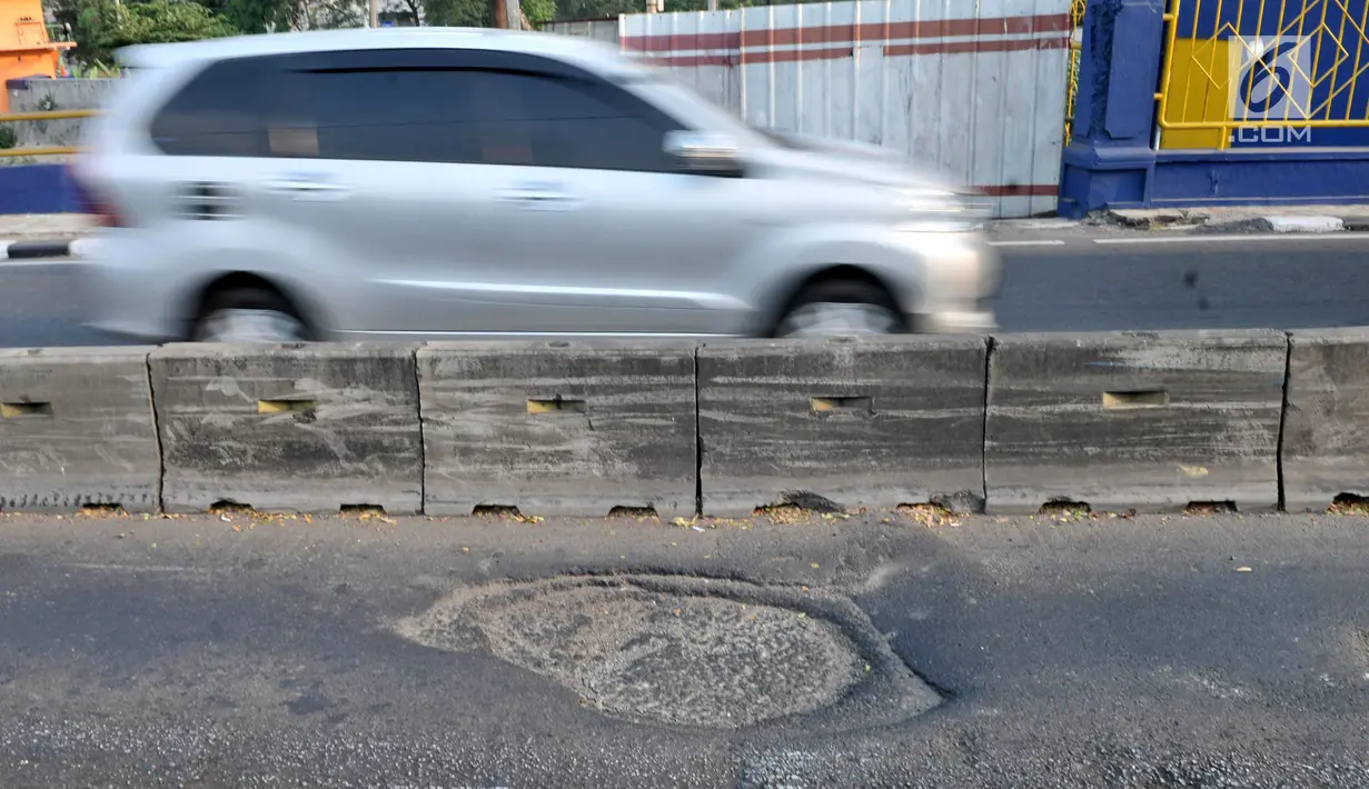 Kendaraan melintas di jalur bus Transjakarta yang rusak dan berlubang di Setia Budi, Jakarta, Selasa (30/7/2019). Minimnya pengawasan serta perawatan jalan oleh pihak terkait dapat mengakibatkan kecelakaan dan rusaknya bus Transjakarta. (merdeka.com/Iqbal S Nugroho)