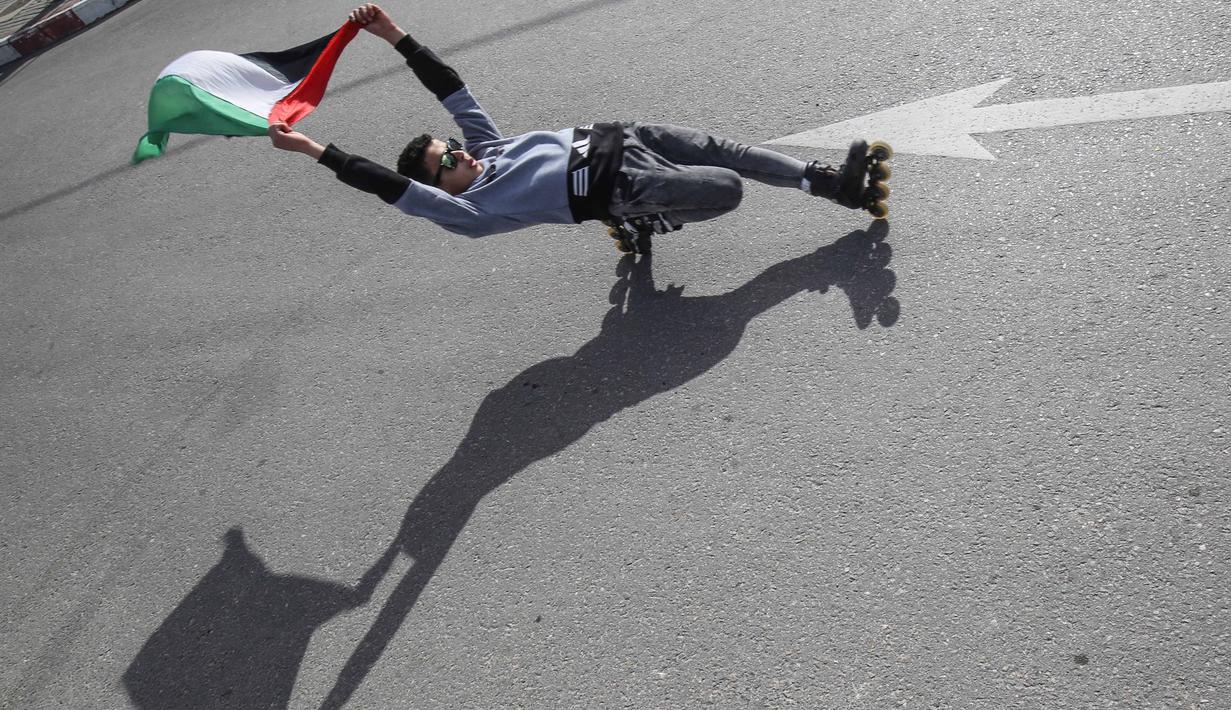 Pemuda Palestina melakukan gaya bebas saat bermain sepatu roda dijalanan kawasan Khan Younis, Jalur Gaza, Selasa (19/1/2021). (AFP/Said Khatib)