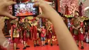Seorang pengunjung tengah mengabadikan sejumlah seniman yang mengenakan busana Dinasti China Swing of Empire Warrior perayaan Tahun Baru Imlek 2568 di Senayan City, Jakarta Jakarta Sabtu (28/01). (Liputan6.com/Fery Pradolo)