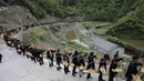 Orang-orang dari etnis minoritas Miao membawa persembahan ketika mereka menghadiri upacara pengorbanan untuk dewa gunung di Jianhe di provinsi Guizhou barat daya China (15/4). (AFP Photo/China Out)