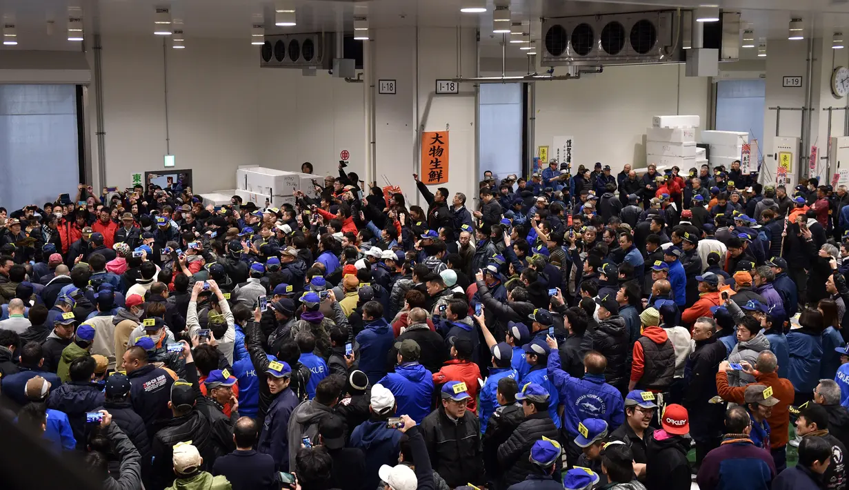 Pedagang grosir berpartisipasi dalam tradisi lelang Tahun Baru di Pasar ikan Toyosu, Tokyo, Minggu (5/1/2020). Lelang terbesar ini digelar pertama usai Tahun Baru, di mana pembeli dari toko grosir hingga taipan sushi akan datang untuk mencari ikan terbaik. (Kazuhiro NOGI / AFP)