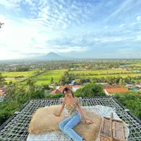 Berpose dengan latar pemandangan sawah, gunung, dan langit yang luar biasa indah, Belleza terlihat mengenakan crop top dengan tali spageti, dipadunya dengan celana jeans panjang. Foto: Instagram.