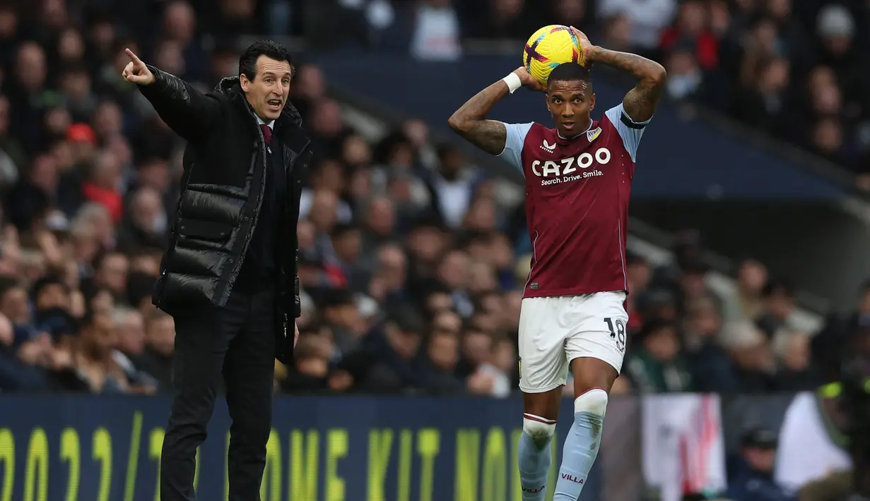 Bek Aston Villa, Ashley Young bersiap melakukan lemparan ke dalam di depan pelatih Unai Emery pada laga Liga Inggris 2022/2023 menghadapi Tottenham Hotspur di Tottenham Hotspur Stadium, London (1/1/2023). Ashley Young didatangkan Aston Villa pada periode keduanya bersama The Villans secara gratis dari Inter Milan pada awal musim 2021/2022. Bertahan selama dua musim dan total tampil dalam 53 laga di Liga Inggris dengan torehan 1 gol dan 2 assist, ia dipastikan hengkang pada akhir musim 2022/2023. (AFP/Adrian Dennis)