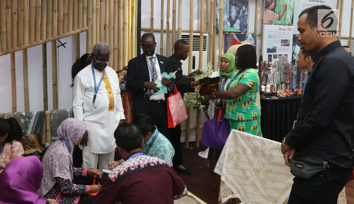 Delegasi Pertemuan Tahunan IMF-Bank Dunia melihat-lihat batik saat mengunjungi pameran Indonesia Pavilion di Nusa Dua, Bali, Minggu (14/10). Lebih dari 20 ribu delegasi mengunjungi Indonesia Pavilion selama 7 hari. (Liputan6.com/Angga Yuniar)